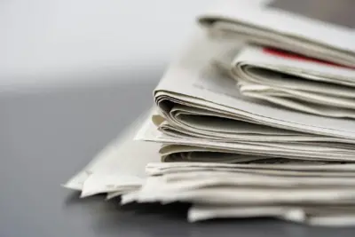 Photograph of a pile of print newspapers