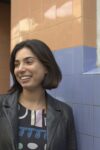 Photograph of Katherine Rajwar in front of tiled wall