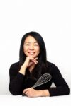 Photograph of Helen Goh holding a whisk